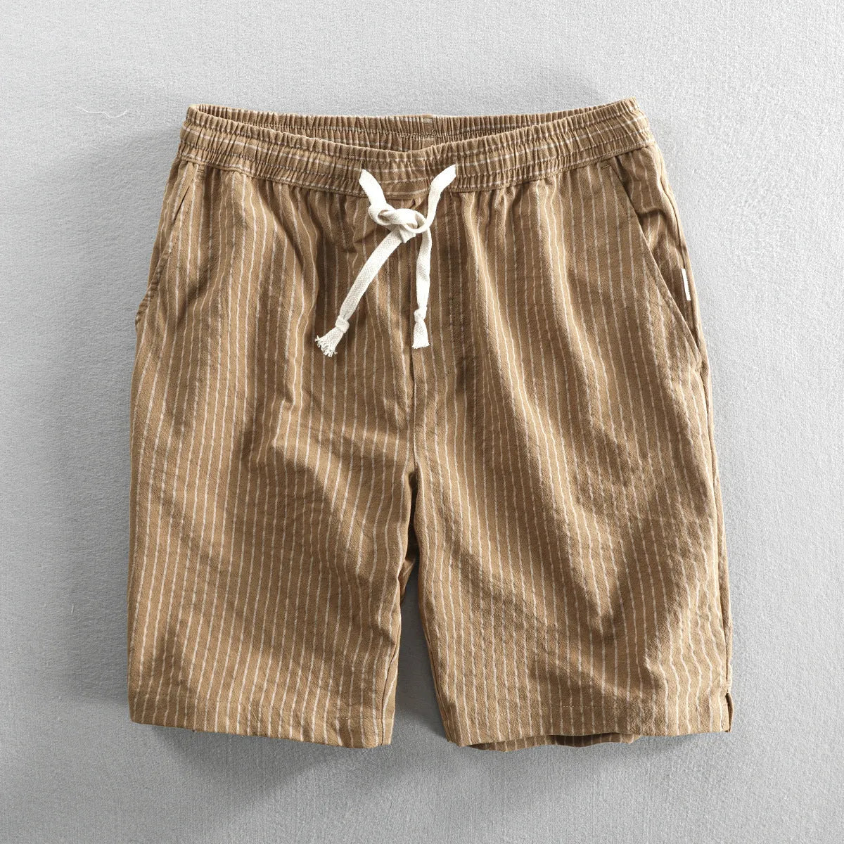 Men's striped cotton shorts in light blue with elastic waistband and micro elasticity, shown in a casual setting.