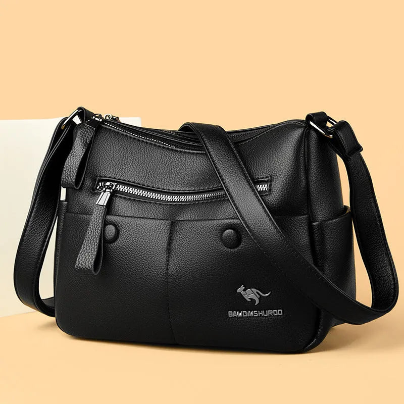Women's soft leather crossbody bag in horizontal square shape with stitching details and crossbody strap