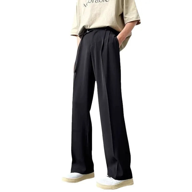 A woman wearing thin black wide-leg straight trousers with a loose, casual fit.