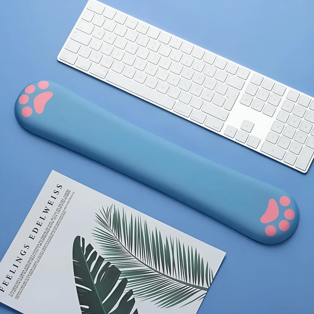 Cat's claw cartoon design memory foam keyboard wrist rest pad in blue, showing its length and thickness on a desk.