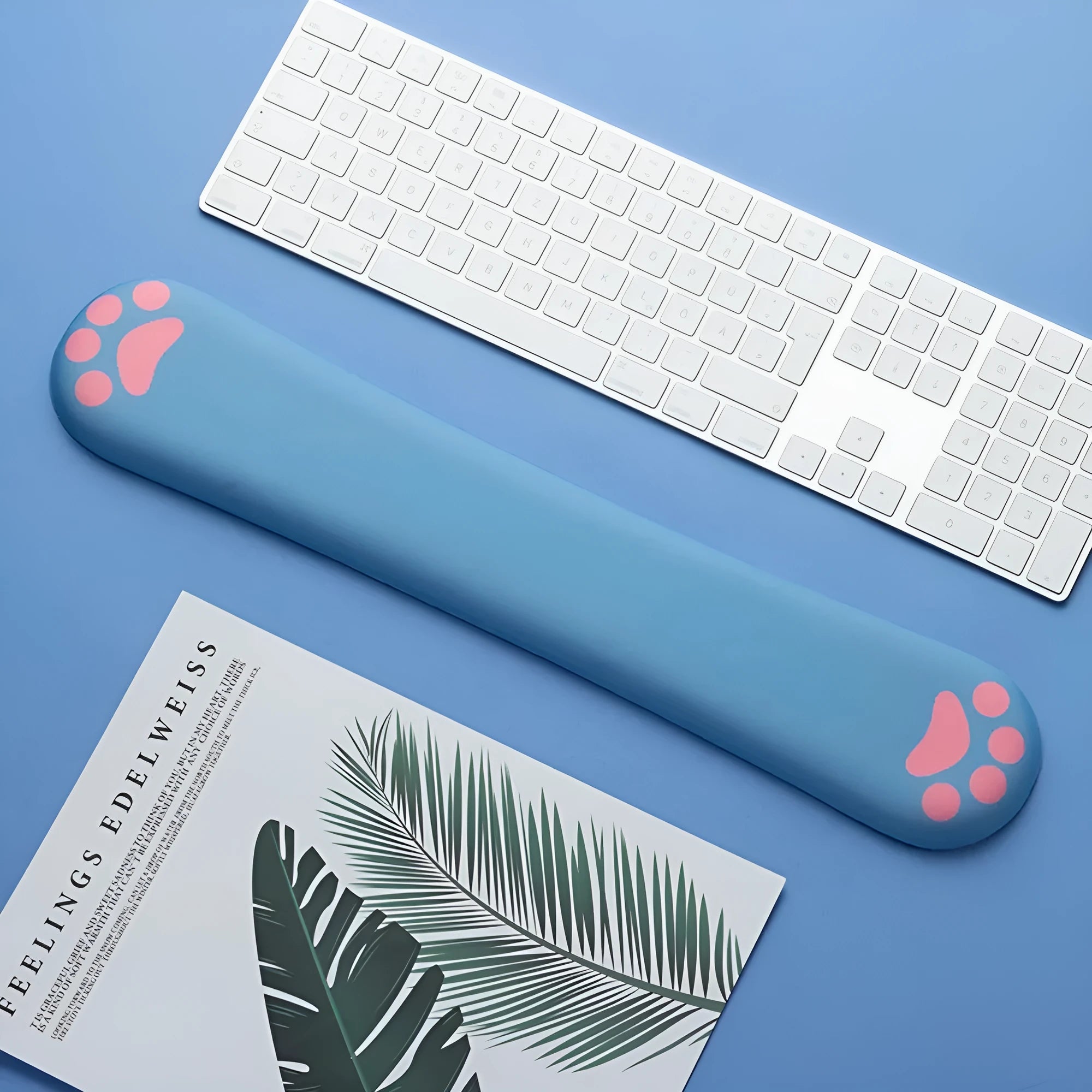 Cat's claw cartoon design memory foam keyboard wrist rest pad in blue, showing its length and thickness on a desk.
