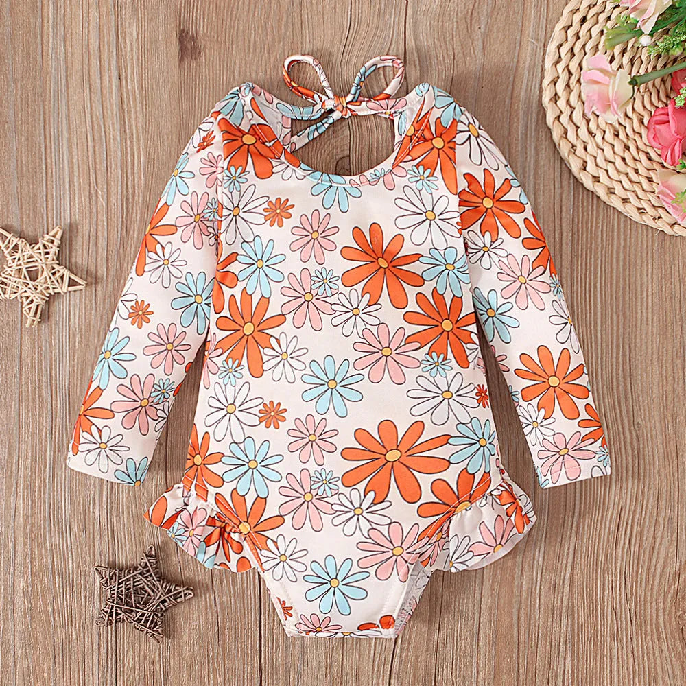 Girl's floral pattern open back swimsuit in polyester fabric showing crew neck design