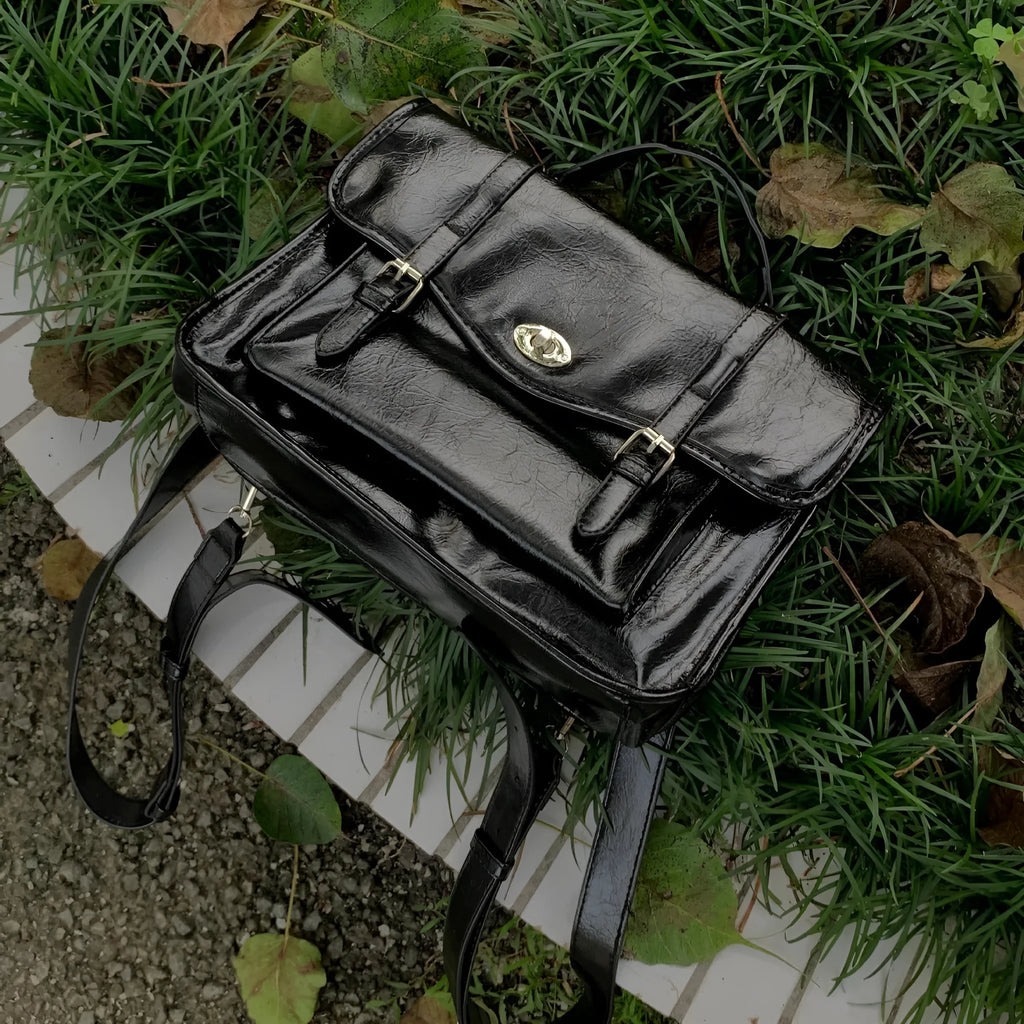 Black college messenger bag with oil wax PU leather finish showing satchel silhouette