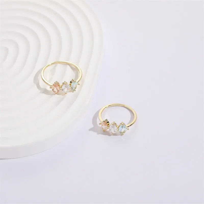 Geometric horse eye ring with tricolour zircon stones on a 14k gold-plated copper band.