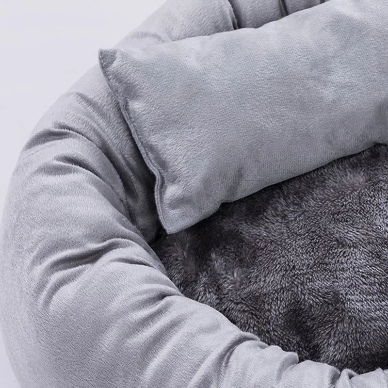 Grey round pet bed for small dogs and cats with raised edges and removable pillow on non-slip base