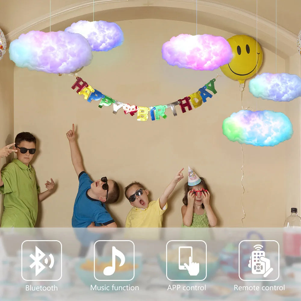 White fabric cloud shaped pendant light with multi-colour LED glow, hanging from a ceiling with a USB cable.