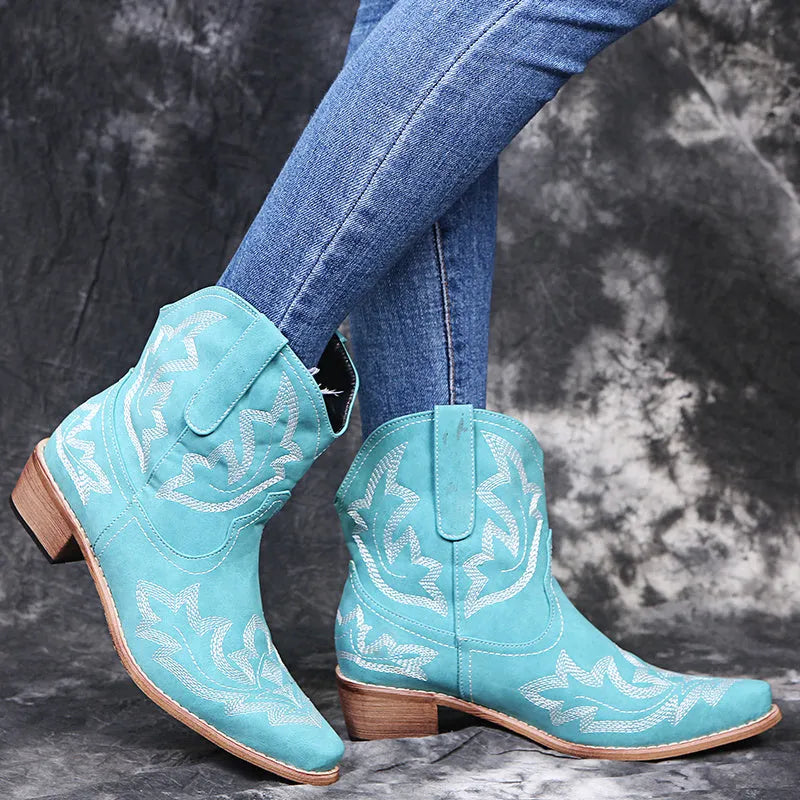 Women's blue cowboy boots with embroidery, wedge heel, and pointed toe on a neutral background