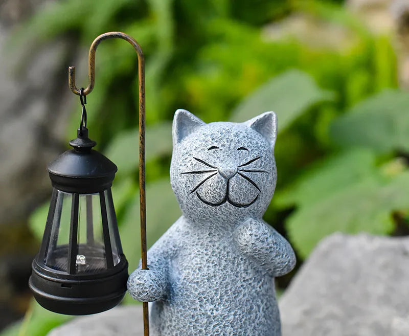 Solar garden light featuring a resin sculpture of a kitten holding up a lantern.