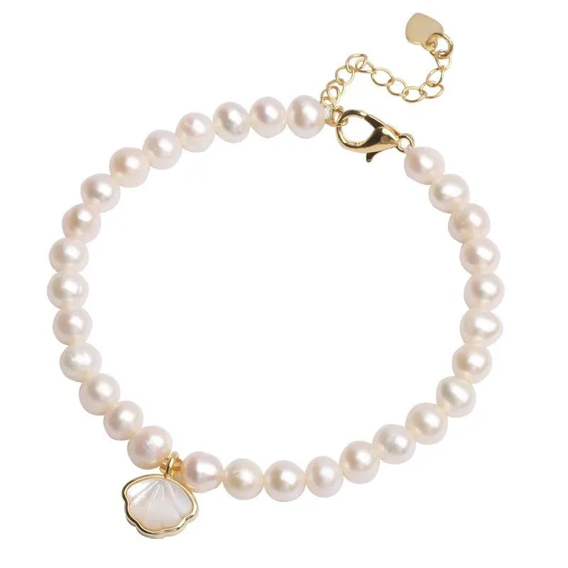 Freshwater pearl bracelet with fan-shaped shell design showing elastic and chain fastening options