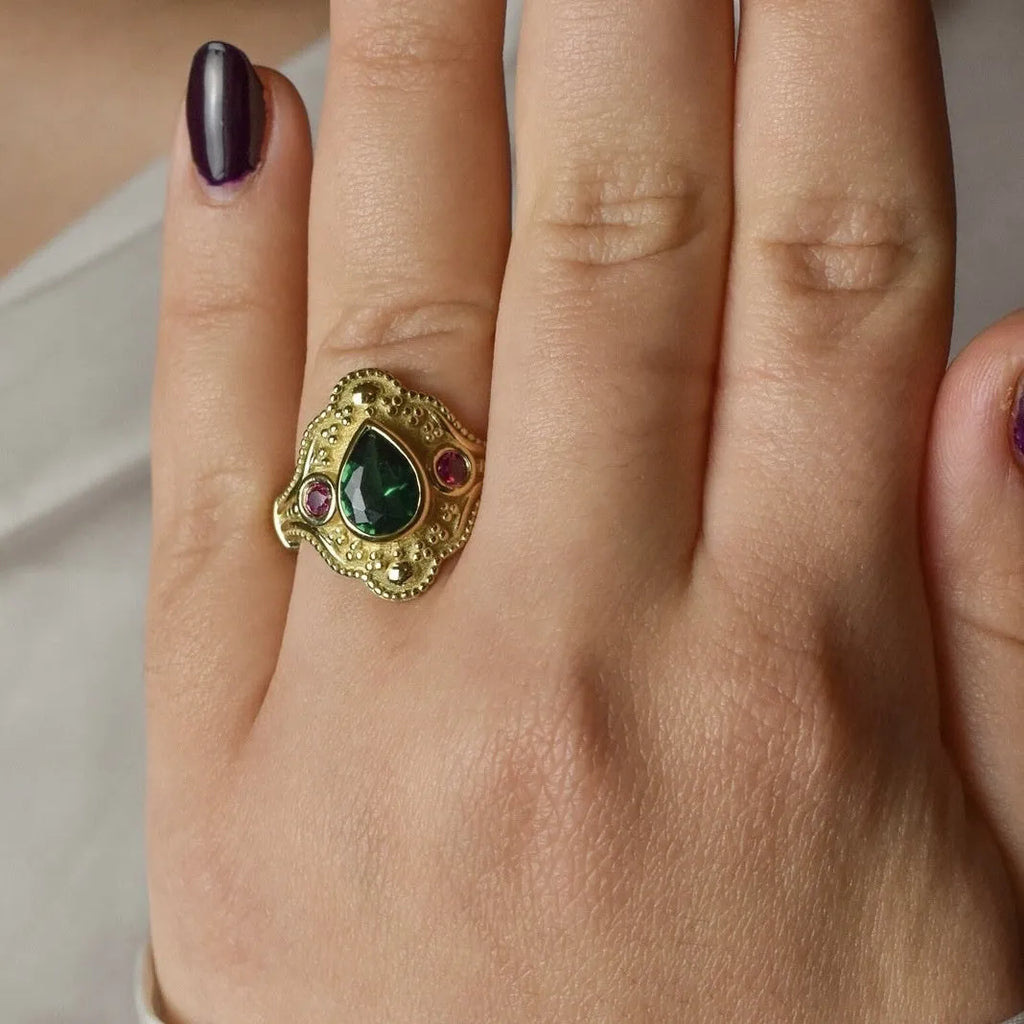 Gold-plated geometric fashion ring for women on grey background showing detailed design
