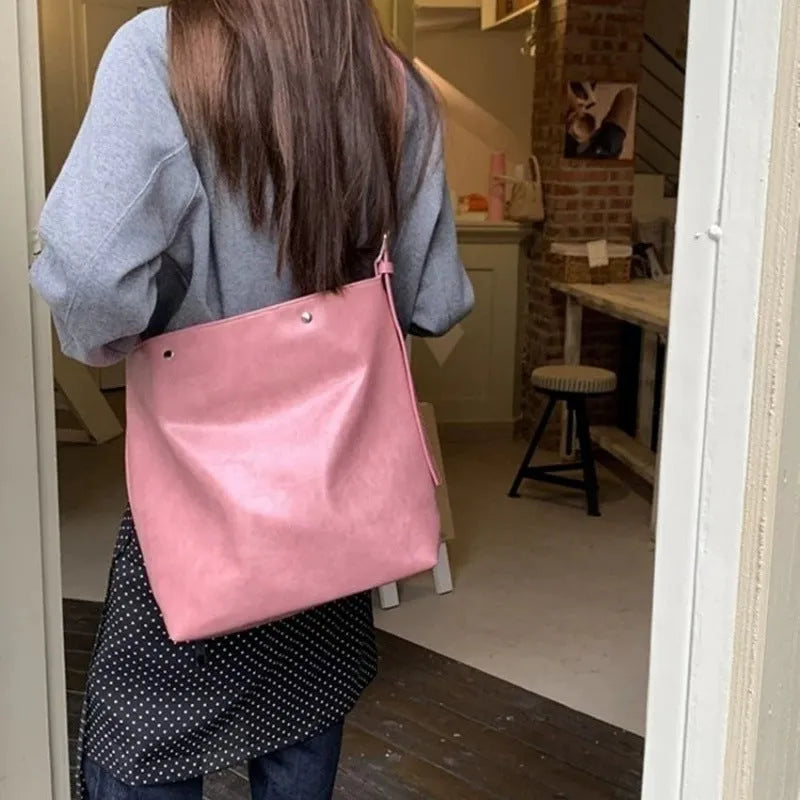 Pink corduroy one-shoulder commuter bag showing size and texture