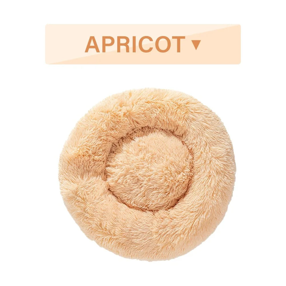 Fluffy donut-shaped dog bed in long plush fabric, shown in a light grey colour with a raised bolster edge.