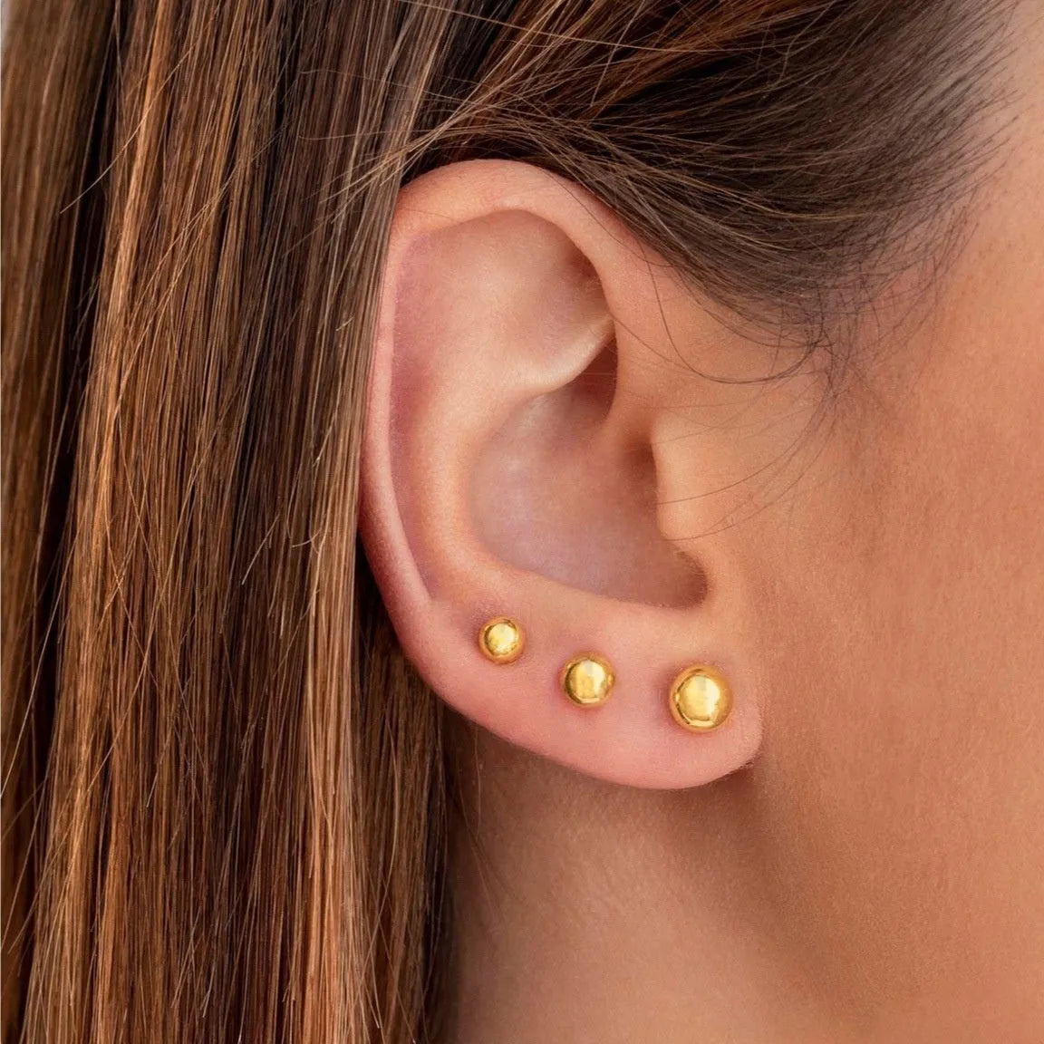 Stainless steel ball stud earrings with round geometric design in gold or silver finish, showing front and side views