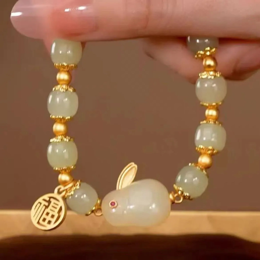 Green jade hare bracelet with black cord showing fu character charm and lily detailing