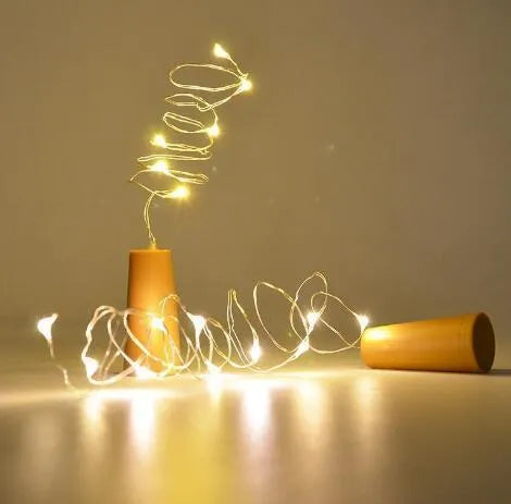 Bendable copper wire LED string lights wrapped around a wine bottle with 20 warm white LEDs glowing