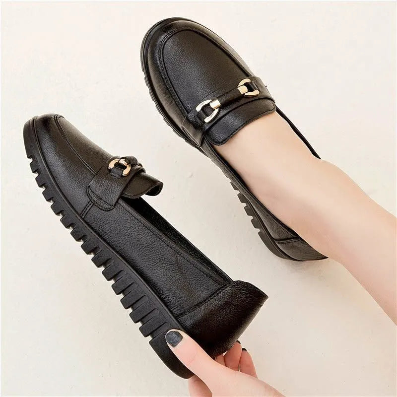 Black women's low-heel leather pumps with a round toe and soft rubber sole.