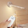 White LED portable night light with a remote control on a wooden surface.