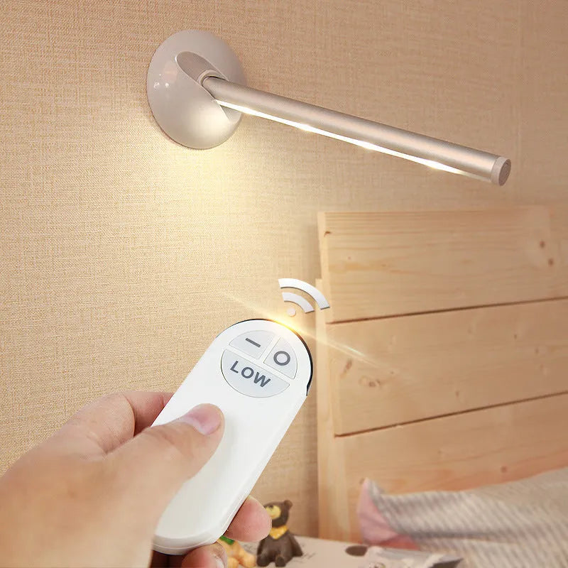 White LED portable night light with a remote control on a wooden surface.