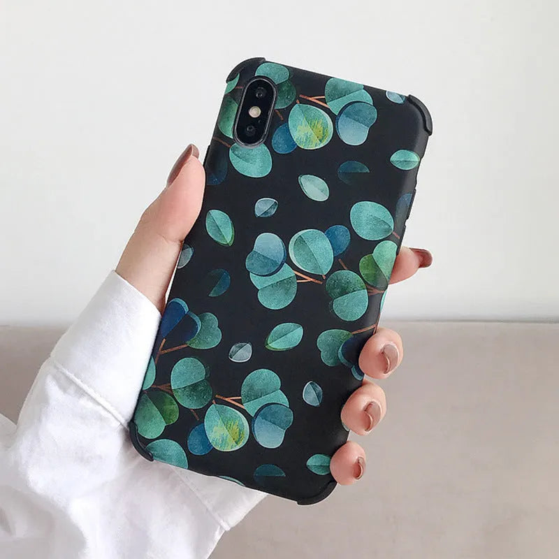 Black silicone iPhone case with a green leaf and botanical floral print design.