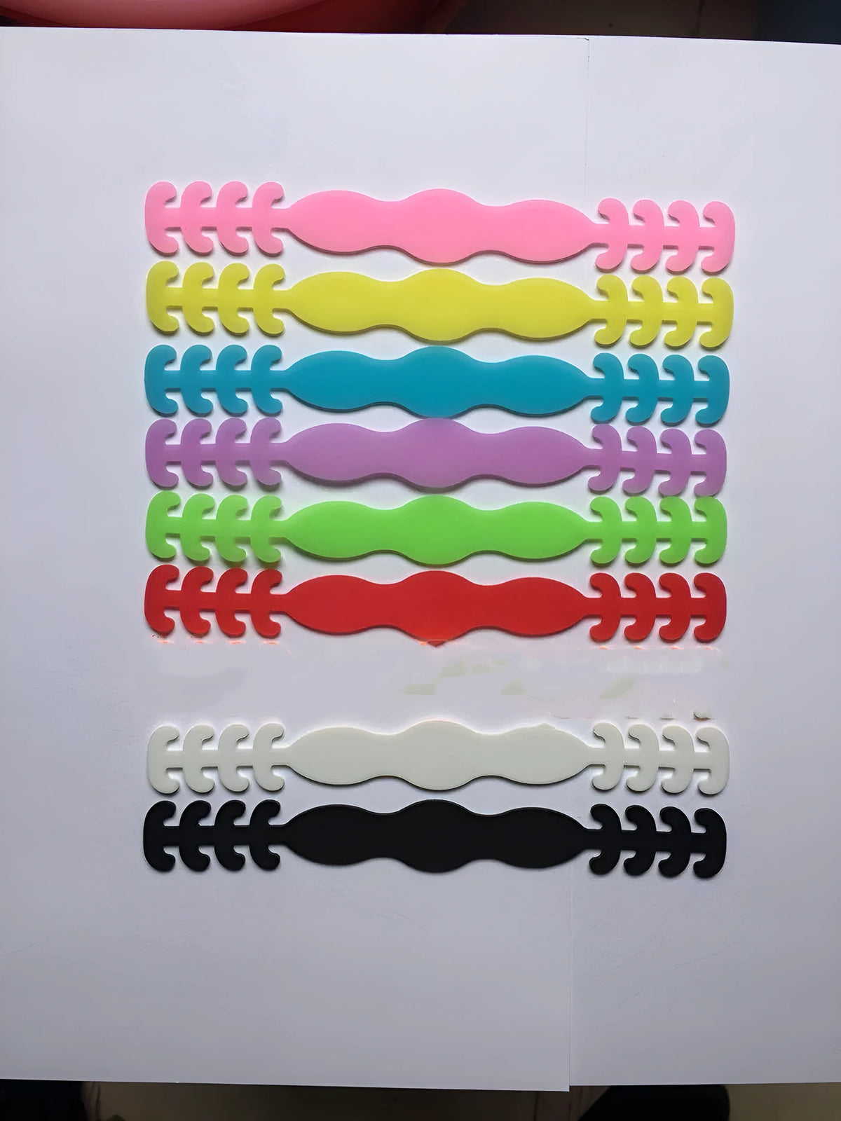 Set of eight small silicone tool buckles in various colours including red, yellow, black, and blue.