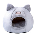Large fully enclosed fabric cat house with a single entrance, shown in a home setting.