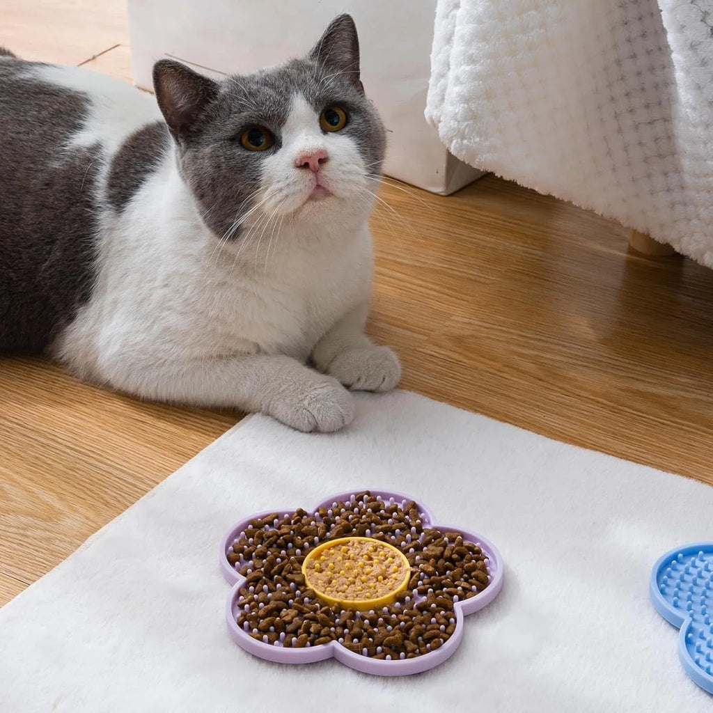 Flower-shaped silicone slow feeder licking mat for dogs and cats with suction cups on a smooth surface.
