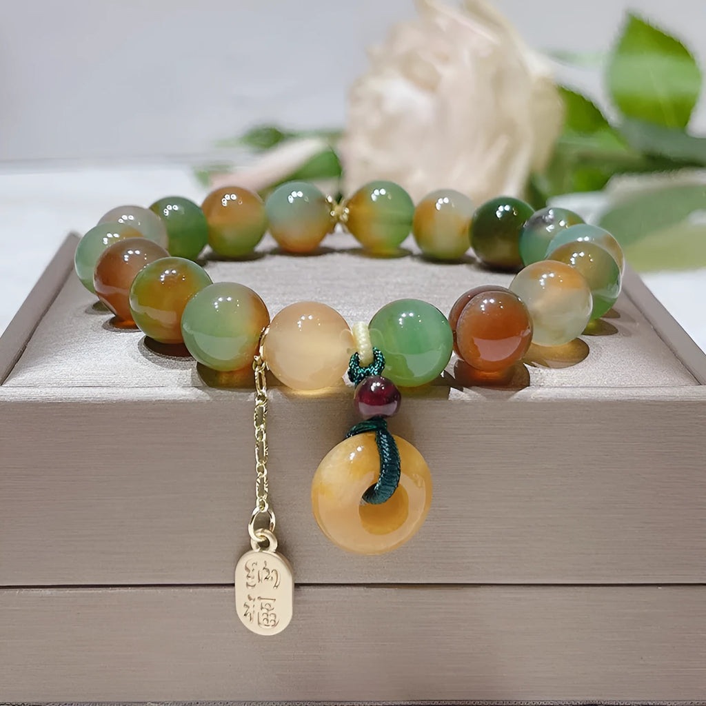 Yellow peacock agate and topaz bracelet with a peace buckle clasp and a lutong agate charm.
