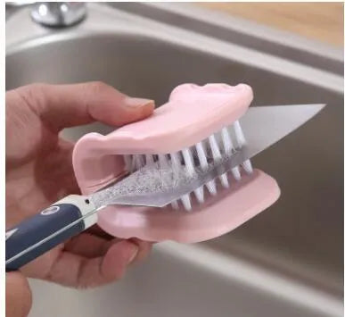 Blue U-shaped plastic brush for cleaning kitchen knives and cutlery on a kitchen counter.