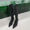 Women's black below the knee boots with pointed toe, 5cm stiletto heel, and back zipper on a solid background.