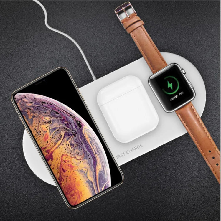 Black wireless charging station with slots for phone, watch, and headphones on a wooden desk