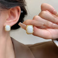 A pair of hand-woven geometric circular earrings in colour X0439, showcasing a vintage Korean style design.