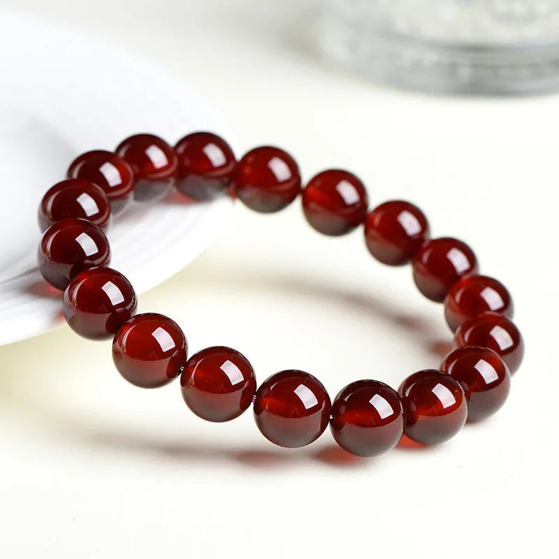 Natural orange red garnet crystal ball bracelet with retro Ruyi design on wrist