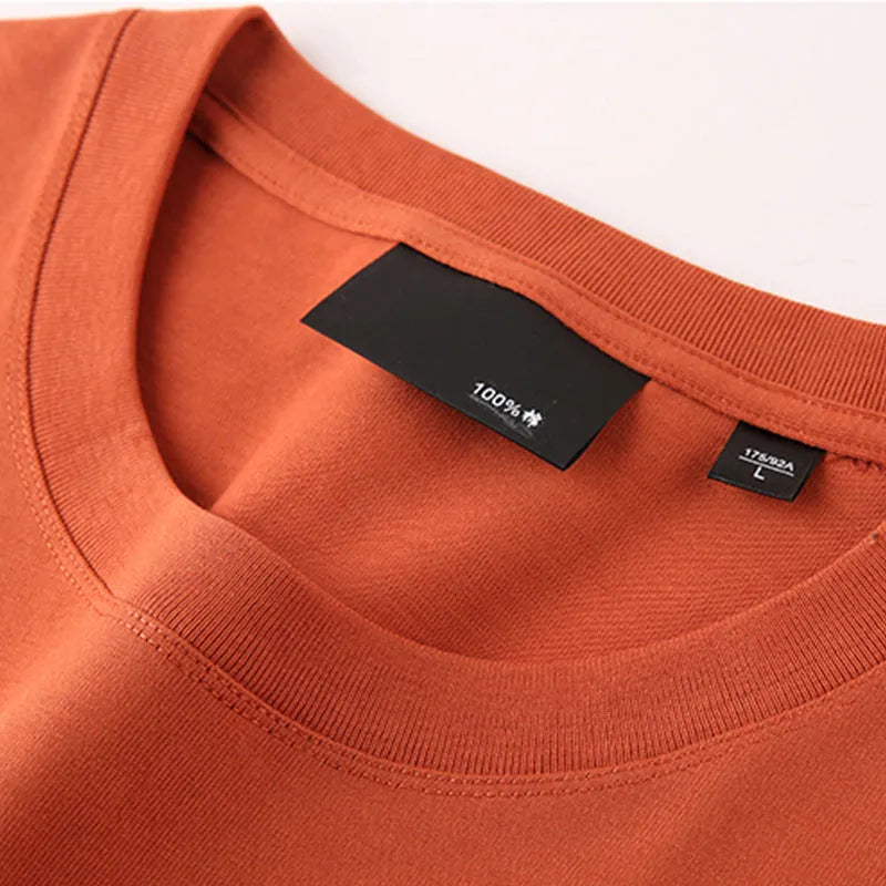 Solid colour loose fit cotton t-shirt with round neck and drop shoulder sleeves on a hanger