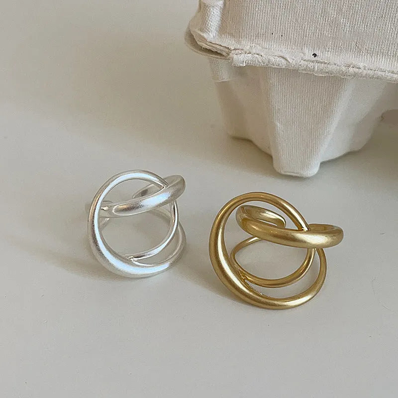 Geometric open ring with interlaced design and matte finish in gold or silver colour with real gold plating