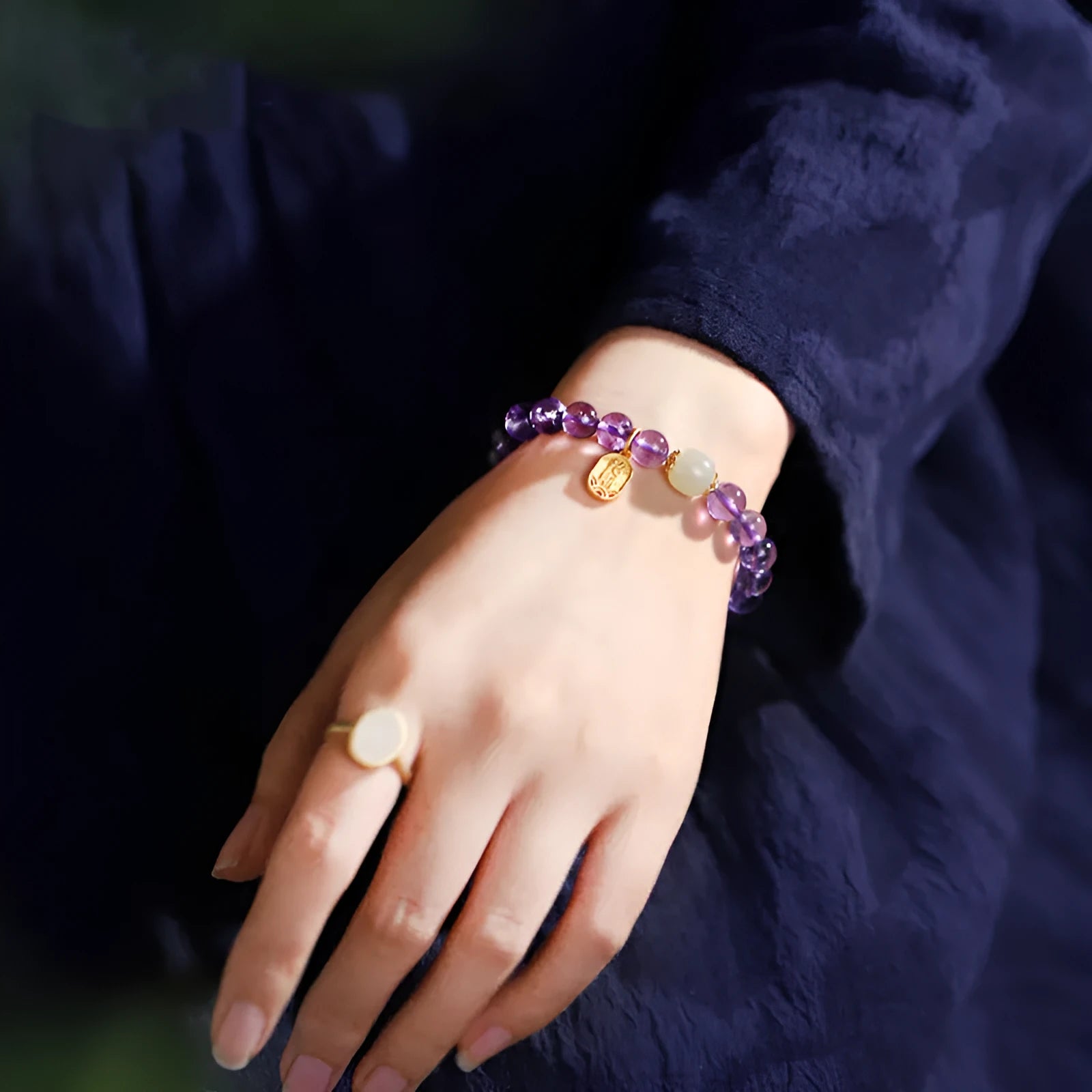 Amethyst purple geometric crystal bead bracelet ornament on a wrist.