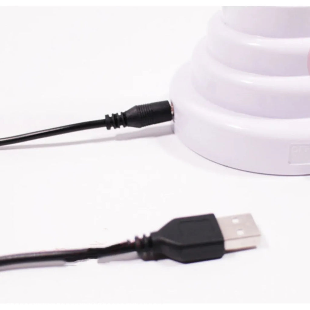 White bamboo-shaped desktop lamp with green light, USB cable, and minimalist design on wooden desk