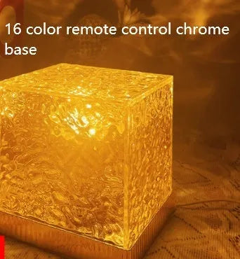 USB rechargeable LED water ripple night light with remote control on a table.