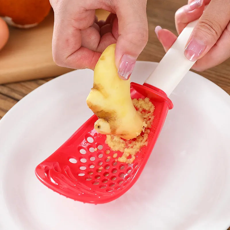 Red and black multifunctional slotted spoon with grinding serrations and half-enclosed head for kitchen use