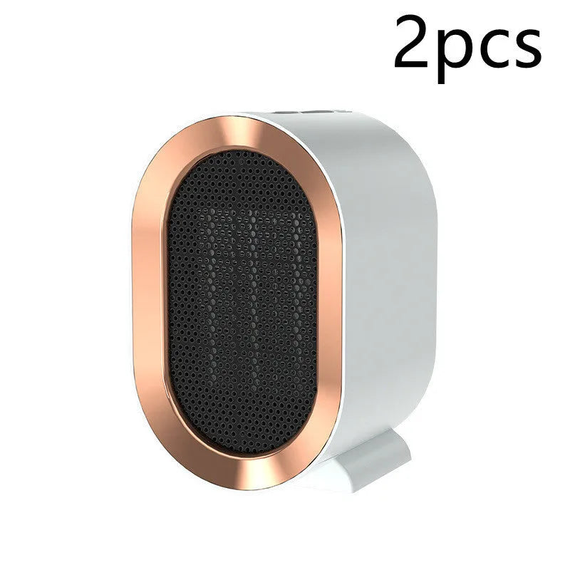 Small black portable ceramic fan heater with UK plug on a wooden desk