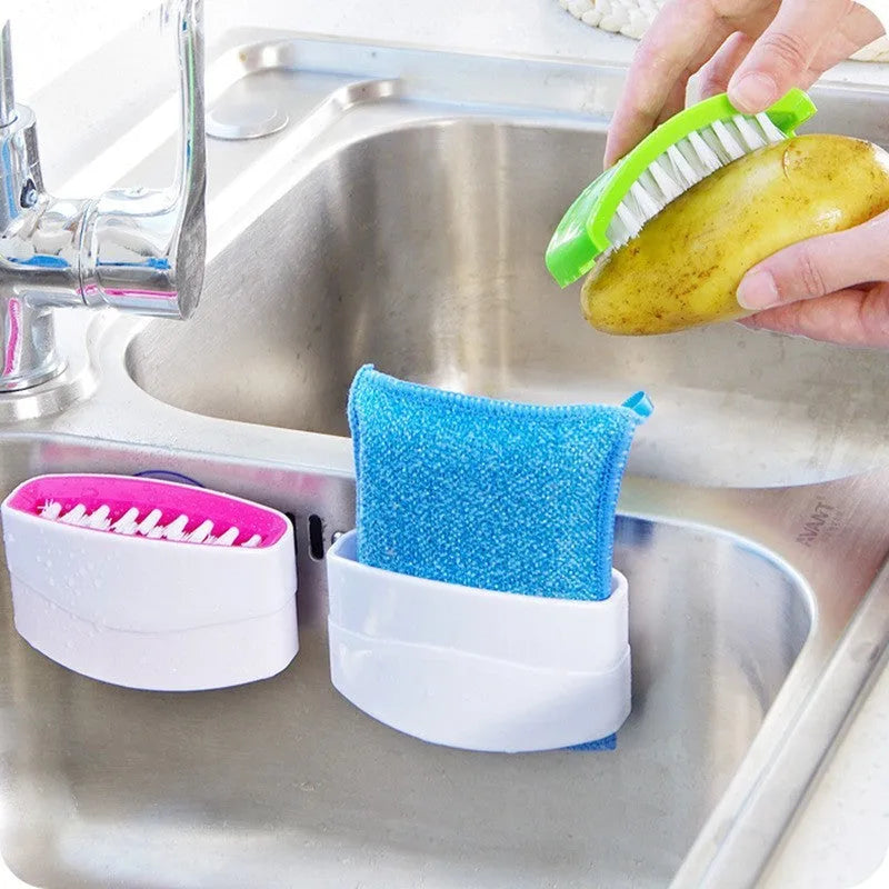 Coloured kitchen brush with knife and fork design and a white suction cup on its handle.