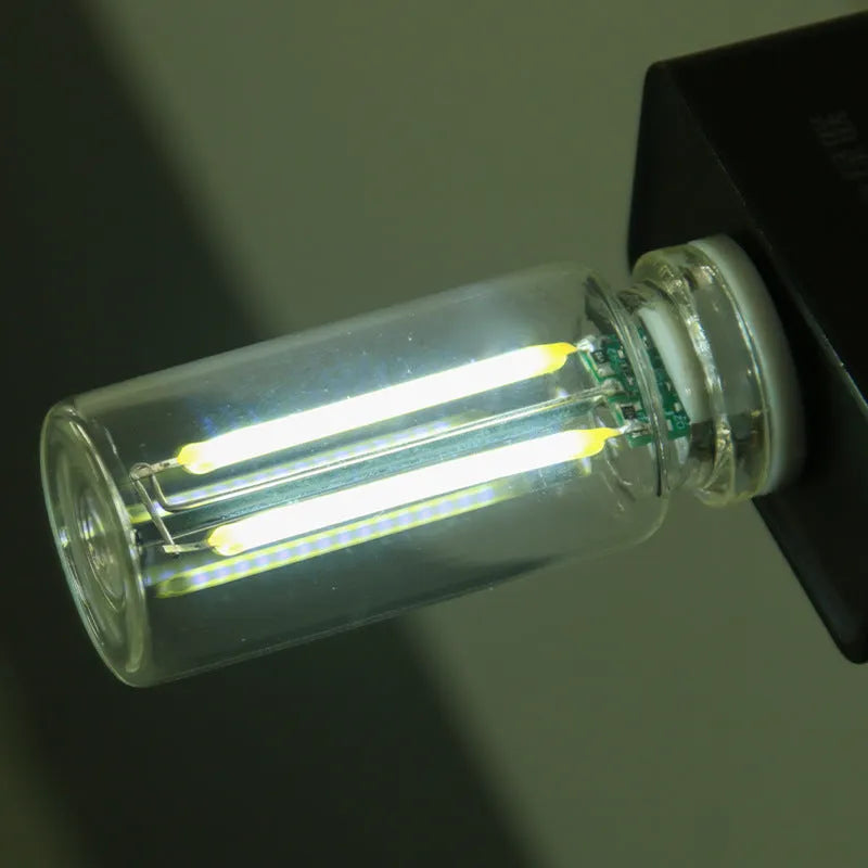 Small transparent glass USB touch night lamp with platinum base on a surface, showing warm white glow.