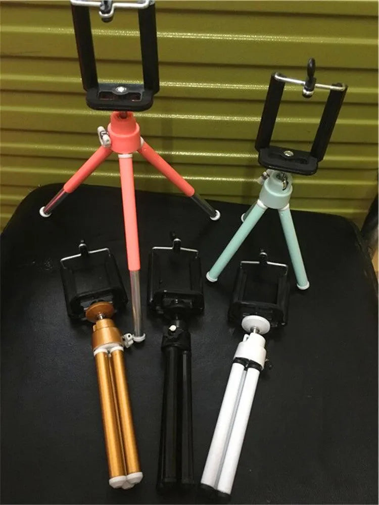 Black desktop phone holder with adjustable two-section bracket on weighted base holding smartphone