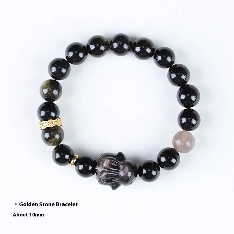Handmade grey obsidian lying rabbit bracelet with brass and silver details on a wrist, shown in 8mm and 10mm size options.