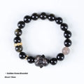 Handmade grey obsidian lying rabbit bracelet with brass and silver details on a wrist, shown in 8mm and 10mm size options.