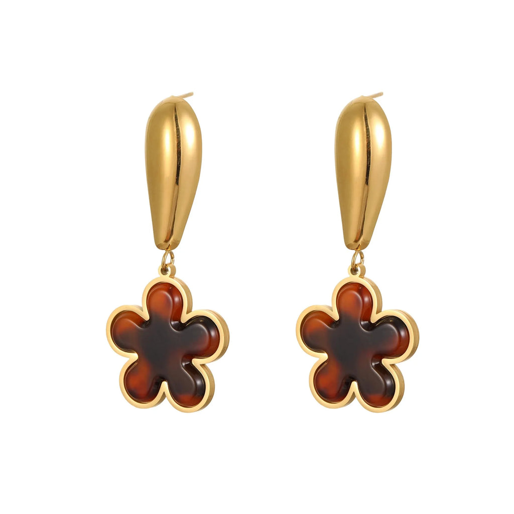 A pair of women's tortoiseshell resin earrings in hawksbill colour, showing heart-shaped and geometric flower designs on stainless steel with 18K plating.