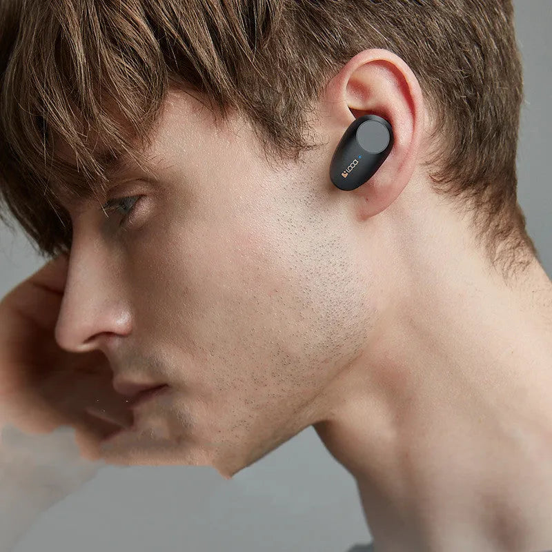 Black wireless Bluetooth earbuds with ANC and a wireless charging stand.