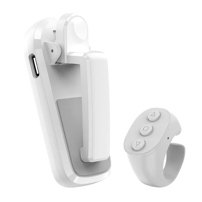 Black wireless page turner remote control and a small clicker on a wooden table.