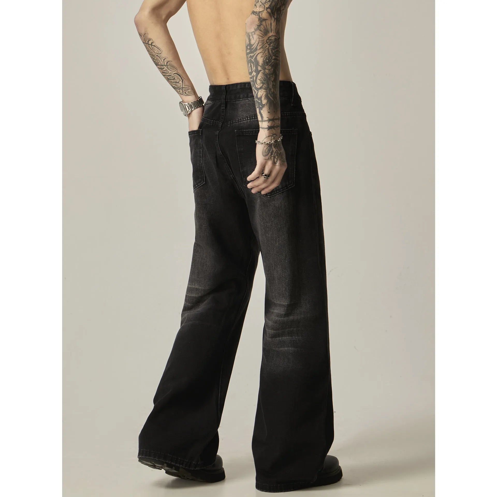 Black loose straight leg jeans with inelastic denim fabric and zipper fly closure