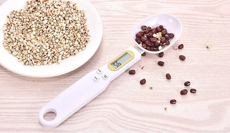 Black electronic measuring spoon scale showing digital display with 0.1g precision for kitchen weighing