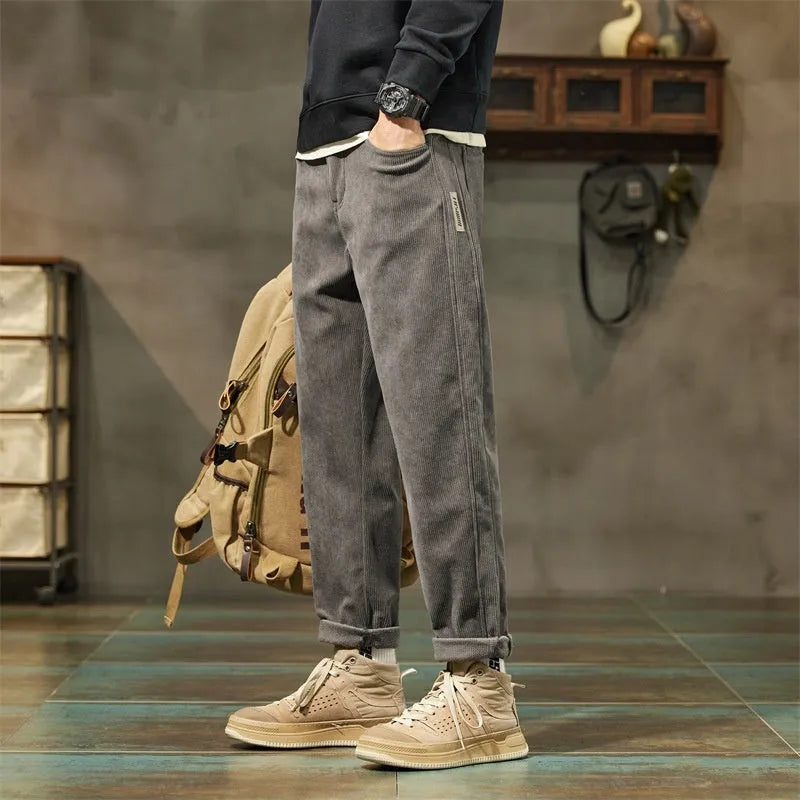 Men's tapered corduroy trousers in army green showing straight-leg street fashion style